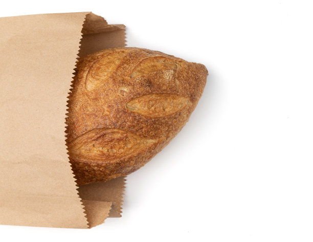 新鲜面包或全麦面包装在纸袋里隔白图片下载