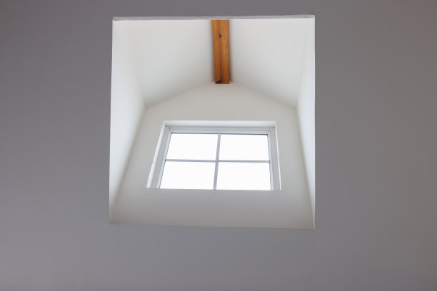 白色倾斜天花板上的屋顶木窗。阁楼的窗户。窗内设计。图片下载