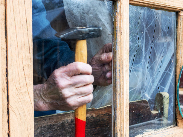 用钉子把窗玻璃固定在木框上图片下载