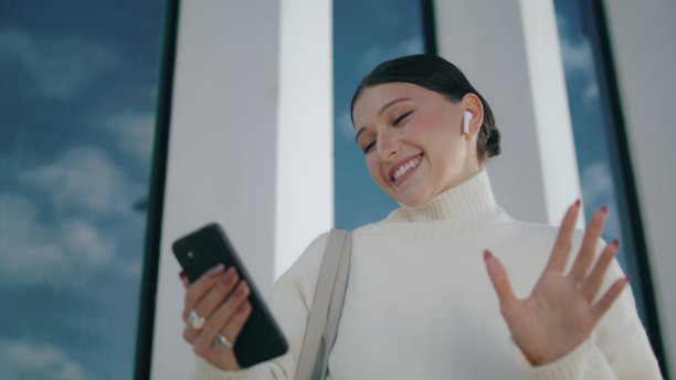 女孩站在街道上用手机拍照。打视频电话的女人。图片下载