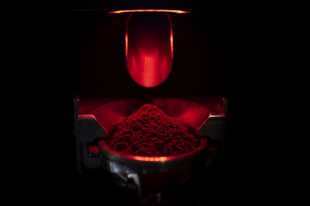 咖啡师用研磨机将刚烤好的咖啡豆磨成粉末图片下载