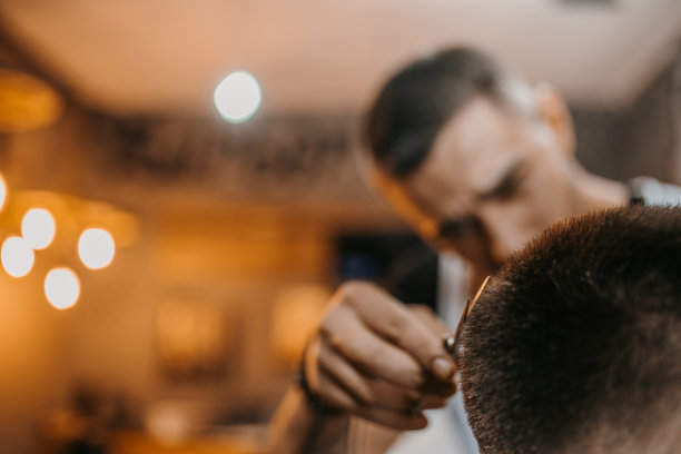 在理发店工作的年轻男理发师图片下载