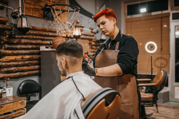 一位年轻的女理发师和一位年轻的顾客在理发店里图片下载