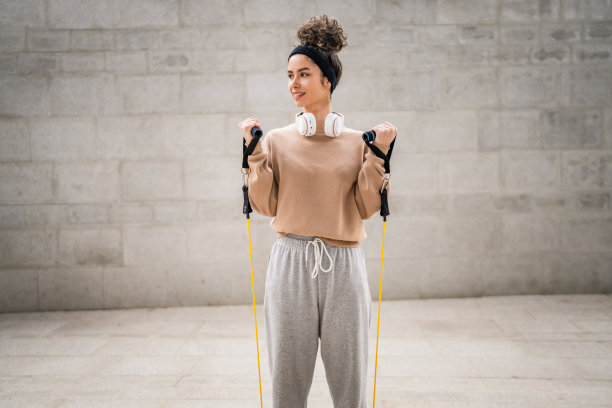 一名妇女在户外用弹性橡胶阻力带训练图片下载