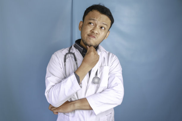 年轻的男医生在孤立的背景下思考一个想法图片下载