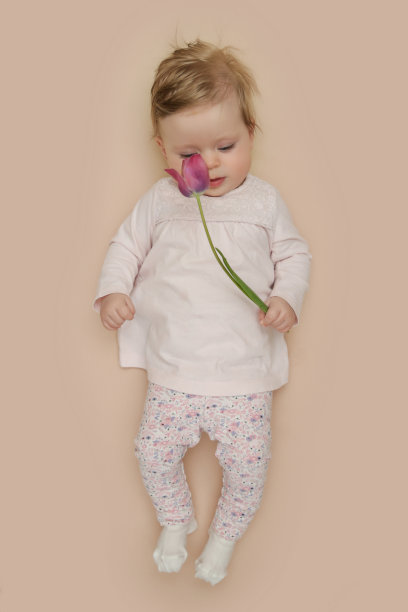 可爱的五个月大的宝宝和粉红色的春天郁金香。春天的使者。婴儿和婴儿里程碑会议。春天的作文。新生儿的照片。3月8日或复活节的明信片概念。图片下载