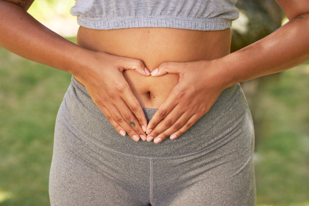 多民族妇女的特写，手在胸前捂着肚子，身体正面图片下载