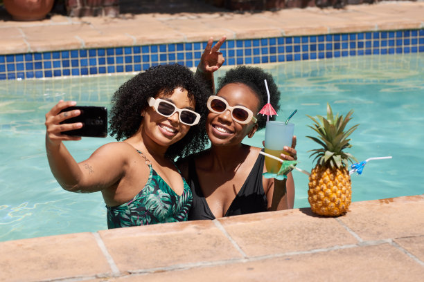 两个黑人朋友在游泳池自拍，夏日度假，无酒精鸡尾酒图片下载