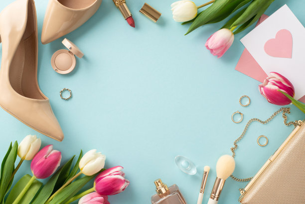 时尚的母亲节概念。顶视图平面布局的高跟鞋，手提包，礼品盒，郁金香，口红，化妆刷，和耳环在柔和的蓝色背景与空白空间的文字或广告图片下载