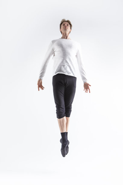 白人英俊的年轻男子在白色衬衫上举起双手，摆出飞行芭蕾舞姿势。图片下载