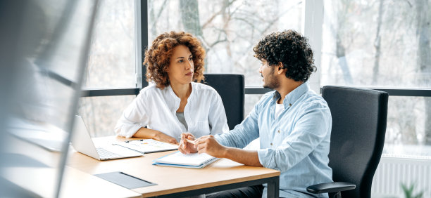 全景照片，两名来自不同国籍的公司员工在一个现代化的办公室里一起为一个新项目工作，一起讨论想法和目标，沟通图片下载