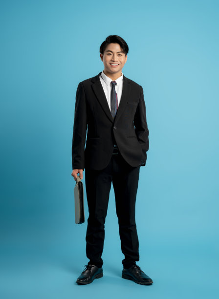 年轻商人在蓝色背景上摆姿势的照片图片下载