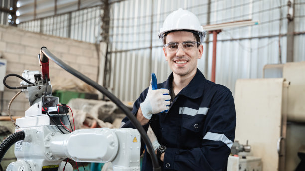 在工业制造工厂中，工业工程师负责控制自动化机械臂、机器焊接机器人。图片下载