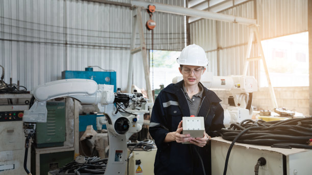 在工业制造工厂中，工业工程师负责控制自动化机械臂、机器焊接机器人。图片下载