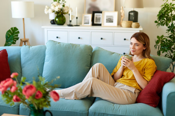 一个迷人的年轻女子在家里喝咖啡放松图片下载