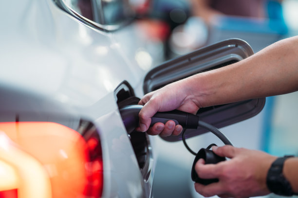 男子用电源插头给汽车充电特写图片下载