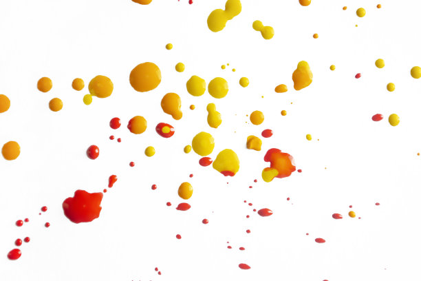 白色背景上的黄色和红色的斑点。白色上的颜料飞溅。白色画布上的颜料滴。图片下载
