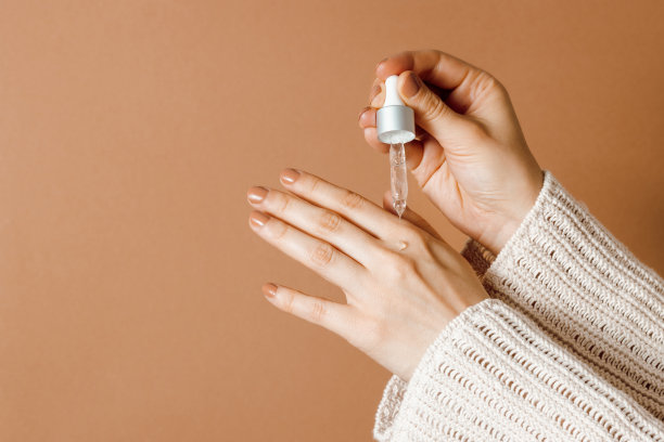 女士正在用精华液涂抹手部皮肤图片下载