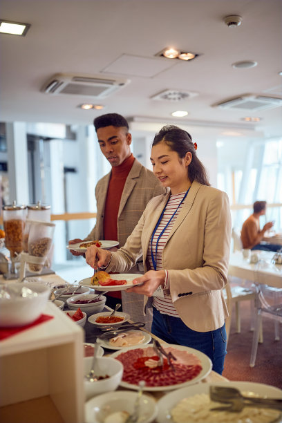 出差的年轻同事正在酒店餐厅享用美食。生意，人，公司图片下载