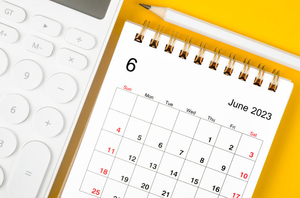 2023年6月月历和计算器，黄色背景上的笔。图片下载