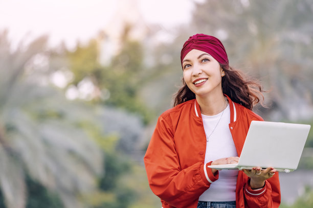 在大自然的包围下，一个女学生在笔记本电脑上打字，她坚定而专注地追求她的学业目标。图片下载