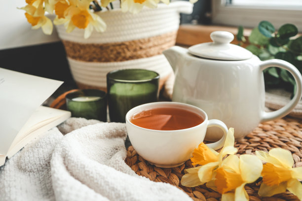 一杯茶，蜡烛，打开的书，篮子里放着水仙花，春天的唯美照片图片下载