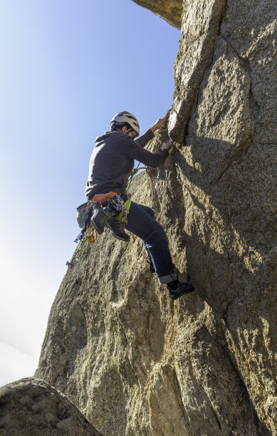 年轻人在马德里的托雷洛多内斯攀爬花岗岩墙。攀岩。极限运动概念图片下载