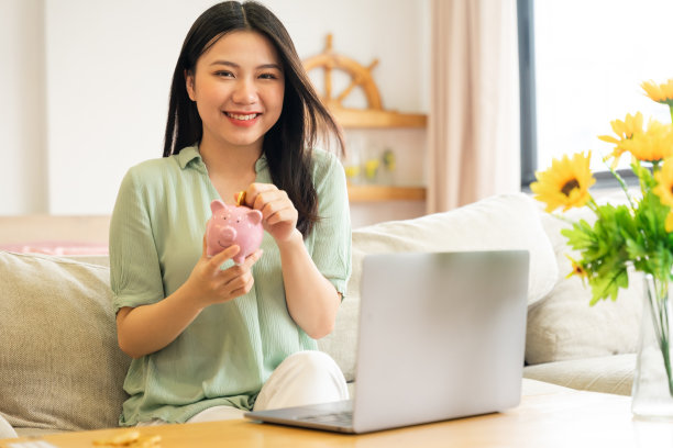 亚洲女孩在存钱罐里存钱的肖像图片下载