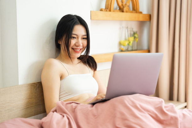 一个美丽而顽皮的亚洲女孩早上躺在床上的肖像图片下载