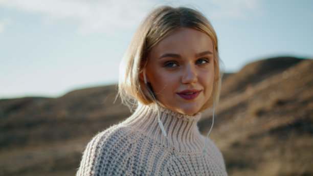 金发模特享受音乐在秋天山谷肖像。学生步行场图片下载