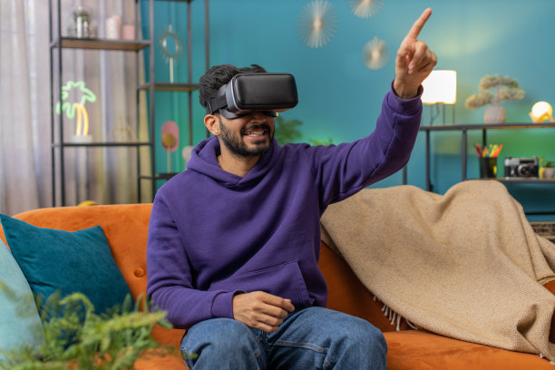 男子使用虚拟现实未来科技耳机在家玩模拟3D视频游戏图片下载