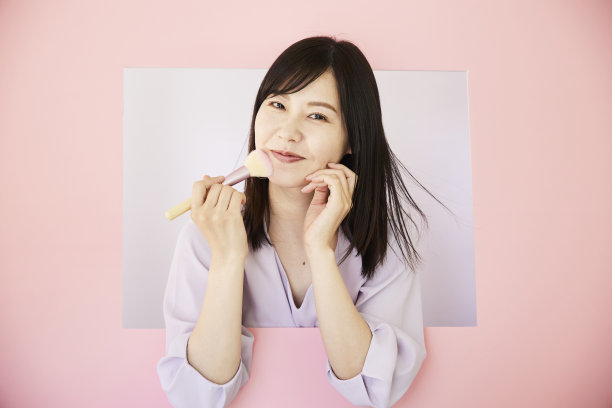 漂亮的亚洲女人从粉色的墙里蹦出来。图片下载