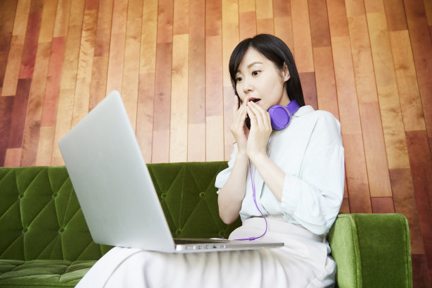 在绿色沙发上休息的亚洲妇女图片下载