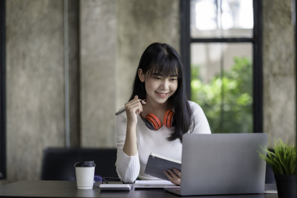 亚洲女学生用笔记本电脑上网学习。年轻的亚洲女商人坐在办公室里做笔记图片下载