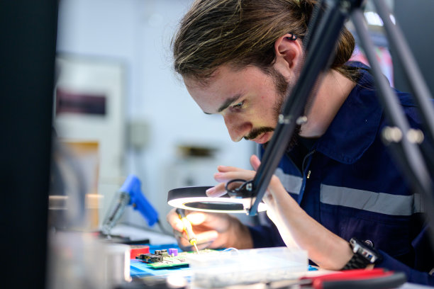 男技术员检查和修理自动机器的一部分图片下载