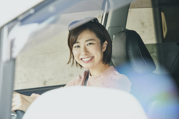 穿粉色衣服开白色车的女人。图片下载