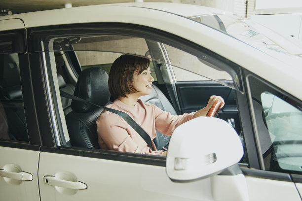 穿粉色衣服开白色车的女人。图片下载