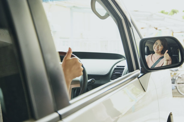 穿粉色衣服开白色车的女人。图片下载