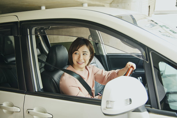 穿粉色衣服开白色车的女人。图片下载