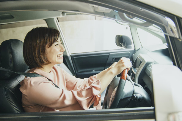 穿粉色衣服开白色车的女人。图片下载