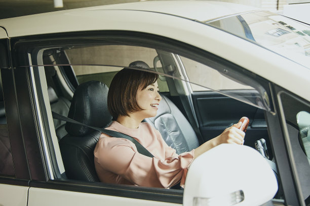 穿粉色衣服开白色车的女人。图片下载