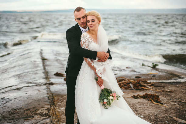 新郎和新娘迎风站在海边图片下载