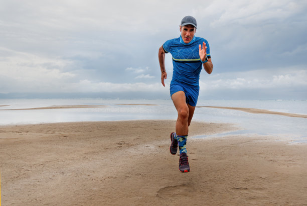 在沙滩上跑步的中年男子。中年健康与健身的观念。图片下载