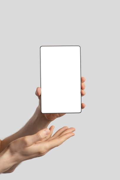 一个欧洲人手里拿着一块平板电脑，背景是孤立的灰色图片下载