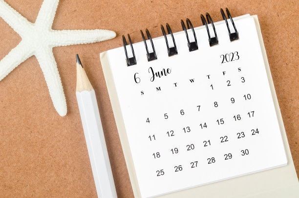 2023年6月月历，木制背景上有海星和铅笔。图片下载