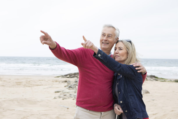 一对成熟的夫妇在沙滩上指指点点图片下载