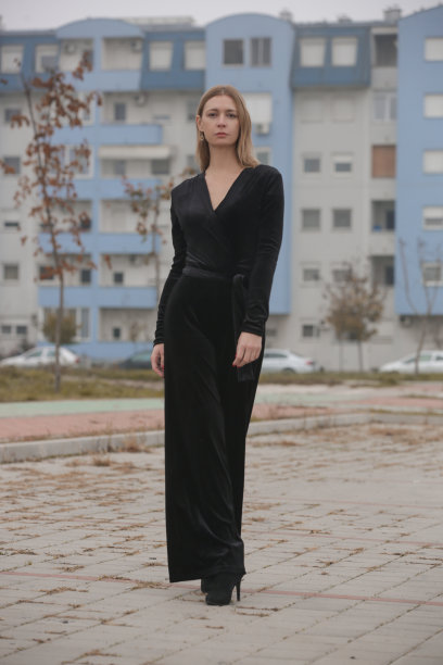 户外肖像的女人在黑色天鹅绒连衣裤在城市，秋季时装系列图片下载
