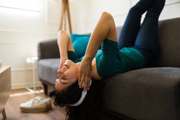 美丽的女人放松，在家听音乐，玩得开心图片下载