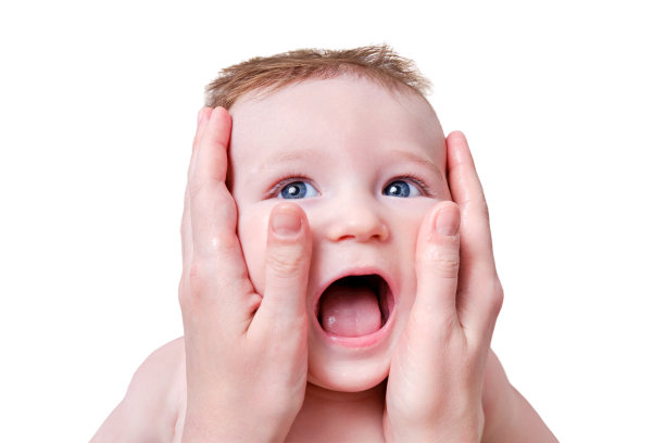 母亲的手正在给一个快乐的婴儿涂抹奶油，孤立在白色的背景上。妈妈在沙发上给六到七个月大的微笑幼儿按摩图片下载