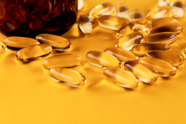 鱼油丸玻璃瓶子在黄色的背景俯视图图片下载